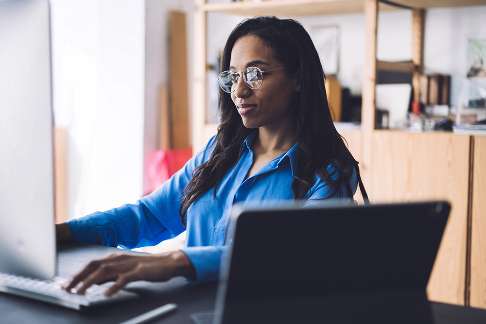 A woman takes an online training at her desk.