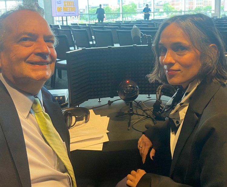 A man and a woman sitting in front of interpretation equipment