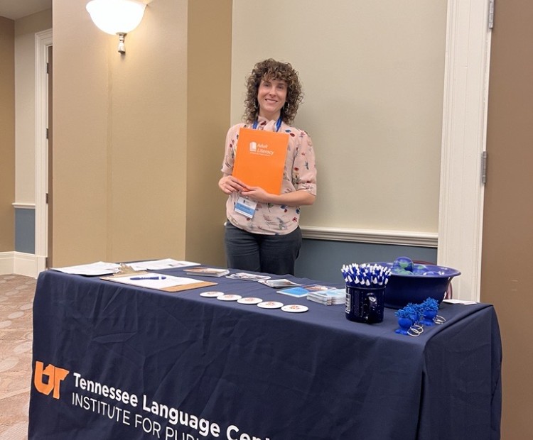 Woman holding a folder standing behind a table display
