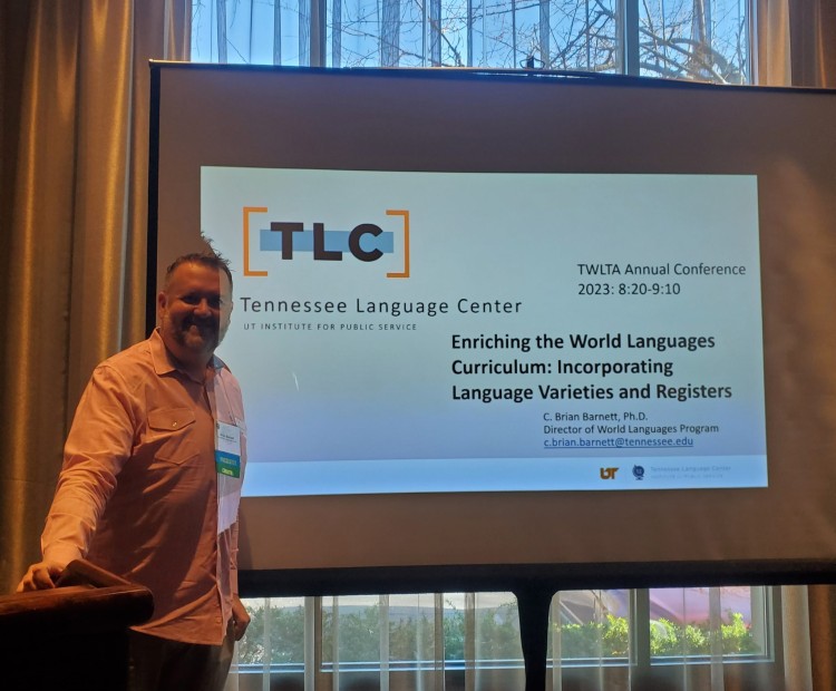 TLC's Brian Barnett standing in front of a screen with a PowerPoint slide