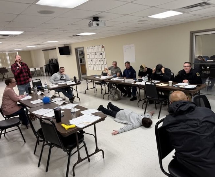 Class of officers deciding how to handle a suspect on the ground