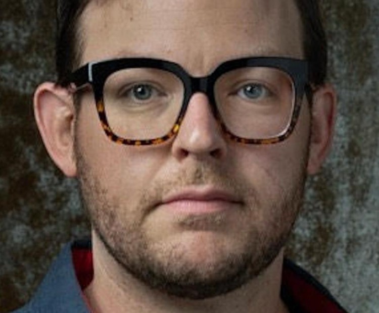 Headshot of a man wearing glasses. 