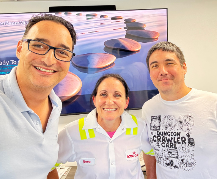 A man in glasses, a woman and another man pose for a selfie