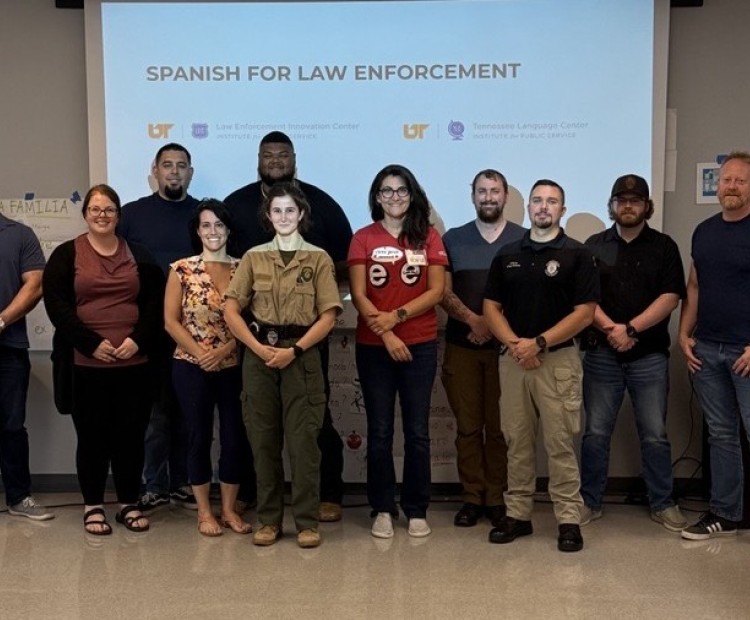 Group of people posing in front of a screen after class