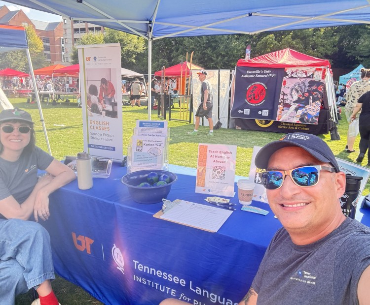 Man and woman in hats and sunglasses sitting at a booth