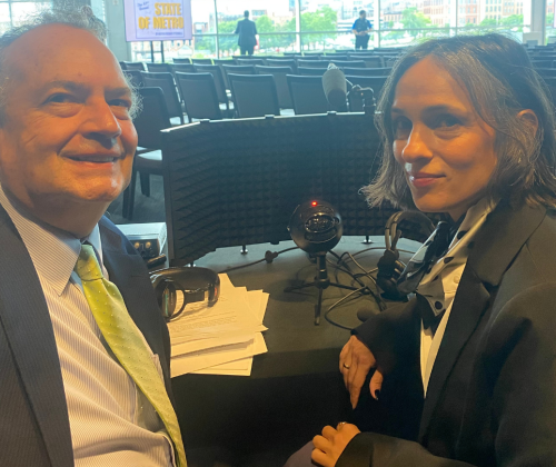 A man and a woman sitting in front of interpretation equipment
