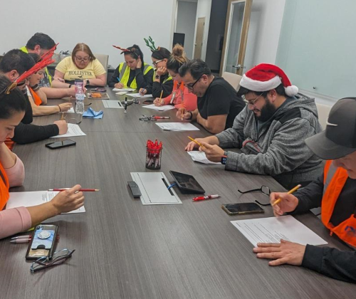 People sitting around a table taking a written test