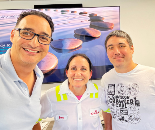A man in glasses, a woman and another man pose for a selfie