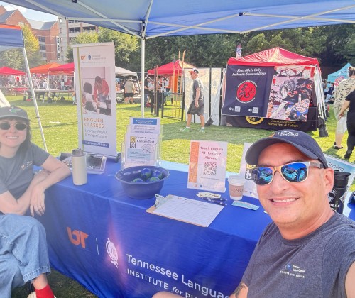Man and woman in hats and sunglasses sitting at a booth