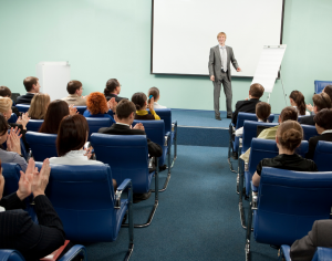 a man standing in front of conference participants