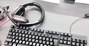 Photo of headphones laying on a computer keyboard to represent audio transcription and translation
