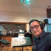 A man wearing headphones sitting in a recording studio